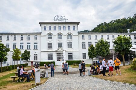 Broc, Switzerland - July 27, 2019: Visitors waiting in front of the building of the famous Cailler chocolate factory. People in the courtyard of the areal. Tour and museum. Swiss chocolate.のeditorial素材