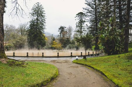 Furnas, Azores, Portugal - Jan 13, 2020: Hot spring iron water thermal pool in Terra Nostra Garden. The pool is surrounded by green botanical garden. Portuguese tourist attraction.のeditorial素材