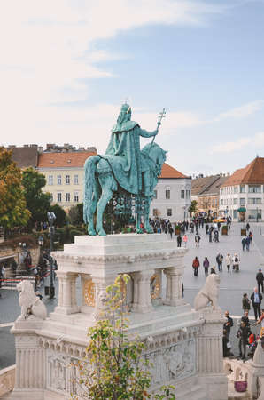 Budapest, Hungary - Nov 6, 2019: St. Stephen equestrian statue from behind. Tourists sightseeing on the square by the Fishermans Bastion in Hungarian capital city. Vertical photo.のeditorial素材