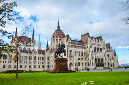 Budapest, Hungary - Nov 6, 2019: Building of the Hungarian Parliament Orszaghaz. The seat of the National Assembly of Hungary. Equestrian statue of Ferenc Rakoczi II and green grass in the foreground.のeditorial素材