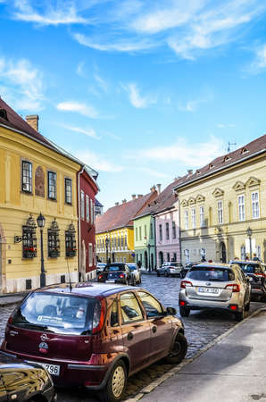 Budapest, Hungary - Nov 6, 2019: Beautiful historical street with colorful houses in the historical center. Parked cars on the cobbled road. Old town of the Hungarian capital city. Vertical photo.のeditorial素材