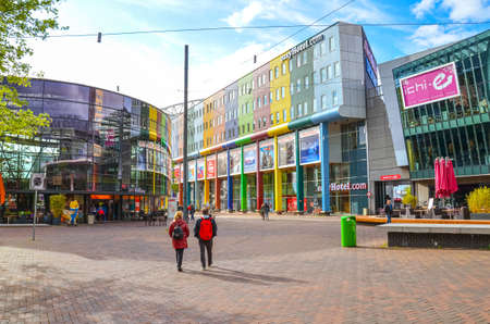 Amsterdam, Netherlands - April 27, 2019: Business district in the Dutch capital. Commercial buildings and hotels with colorful facades. People on the street, daily life.のeditorial素材