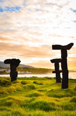 Amazing stone formation by the Populo Beach, Praia do Populo in Sao Miguel Island, Azores, Portugal during sunrise. Morning dawn, stone silhouettes, orange sky. Vertical photo.の写真素材
