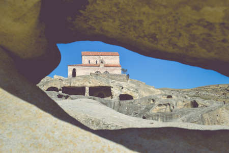 The Uplistsikhe cave complex near Gori, Georgia. Three-nave basilica photographed through a hole in the rock. Ancient rock-hewn town in eastern Georgia. Georgian gourist landmarkの写真素材