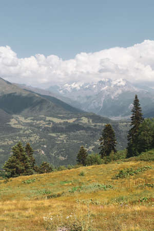 Mountain landscape near Mestia, Svaneti region, Georgia, Asia. Snowcapped mountains, Caucasus mountain range in the background. Blue sky with clouds above. Georgian travel destinationの写真素材