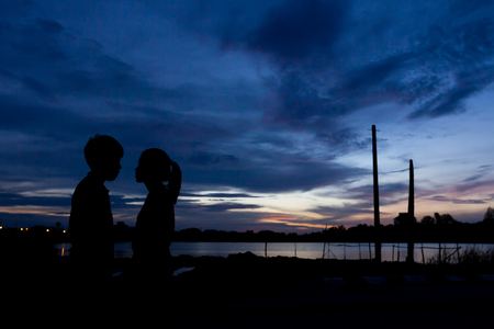 Silhouette couple kissing over sunset background,twilight , blurry, select focusの写真素材