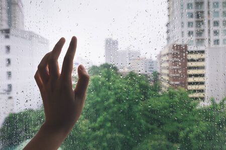 Lonely hand on the mirror during rainの写真素材