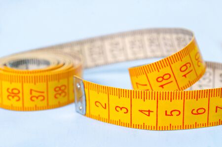 twisted tape measure on blue background