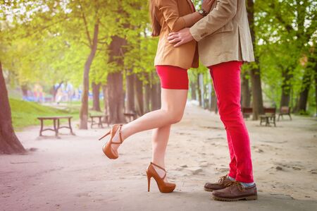 Young fashion elegant stylish couple  feet , in love , stand opposite each other on park in spring sunny weatherの写真素材