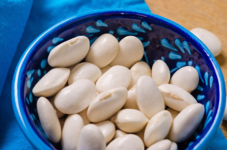 big white beans in a blue plate on a wooden backgroundの写真素材
