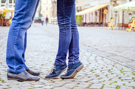 Young fashion elegant stylish couple  feet , in love , stand opposite each other in old city in spring sunny weather, legsの写真素材