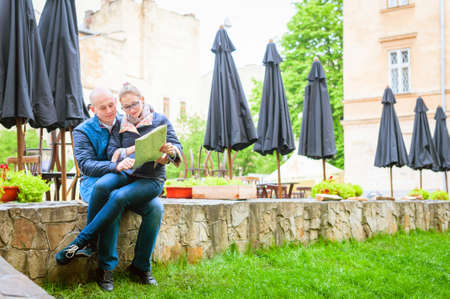 Young fashion elegant stylish couple, travel by old European cities, looking way on the map, smileの写真素材