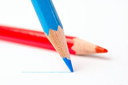 Sharpened blue pencil draws a line on a white paperの写真素材