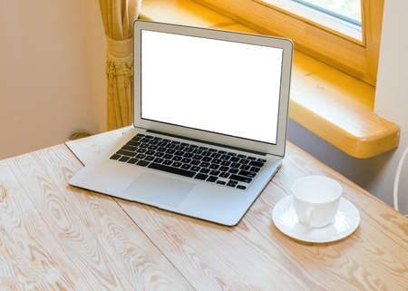 modern laptop on a wooden table in a bright  roomの写真素材