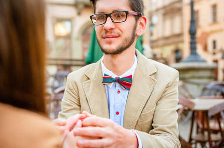 Young fashion elegant stylish couple posing on cafe of european city in summerの写真素材