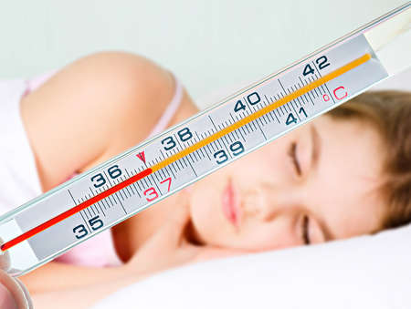 a thermometer and small girl on backgroundの写真素材