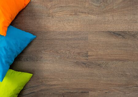stack of bright pillows on a wooden floorの写真素材