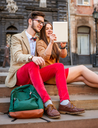 Youngsmile  couple sitting on stairs in summer , photographs selfie on tablet pcの写真素材
