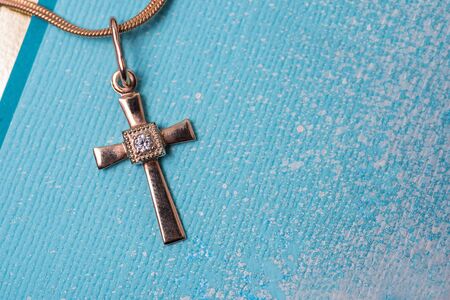 golden cross on a chain on a blue backgroundの写真素材