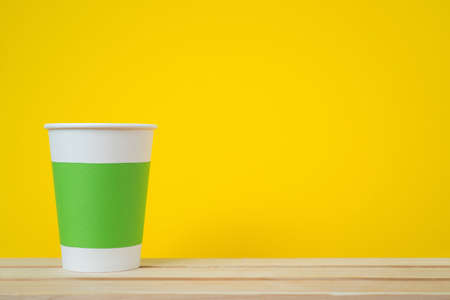 Paper cup with Sleeve on yellow backgroundの写真素材