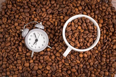 Cup of coffee, clock and coffee beans on a table