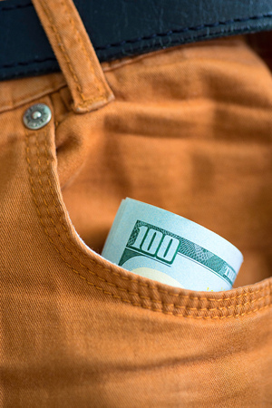 Dollars in the pocket of jeans. Bundle of dollars. Money in the pocket of trousers. Business casual.