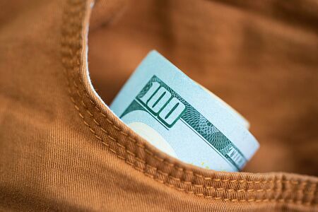 Dollars in the pocket of jeans. Bundle of dollars. Money in the pocket of trousers. Business casual.の写真素材