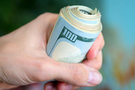 US dollars rolled up in the handの写真素材