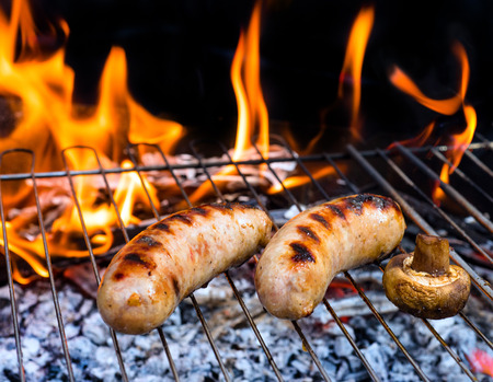 Barbecue grill. Fried sausages. BBQ with fiery sausages on the grill.の写真素材
