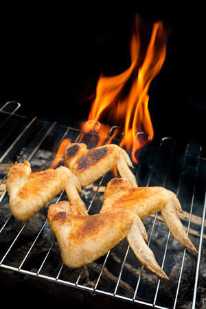 Grill concept. fried chicken wing cooking on hot barbecueの写真素材