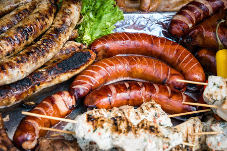 Group of delicious fried sausages and kebab. Picnic on sunny day. Street food. Culinary concept.の写真素材