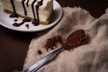 slice of cheesecake with coffee on dark background. cup of coffee and a dessert on plateの写真素材