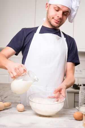 chef cook pours milk in a glassの写真素材