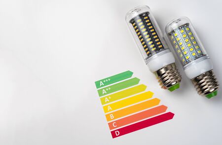 Energy efficiency concept with energy rating chart and LED lamp on white backgroundの写真素材