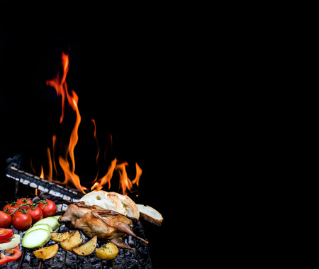 Grilling delicious poultry quails and fresh juicy vegetables in a restaurant on barbecue. Partridge, quail, potato, tomato, zucchini, sweet pepper are prepared on the grill on sunny day. Culinary concept with delicious food.の写真素材