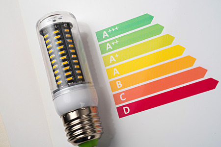Energy efficiency concept with energy rating chart and LED lamp on white backgroundの写真素材
