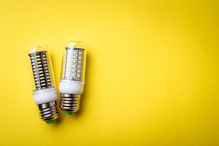 Energy saving LED light bulb on a yellow background with empty spaceの写真素材