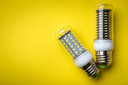 Energy saving LED light bulb on a yellow background with empty spaceの写真素材