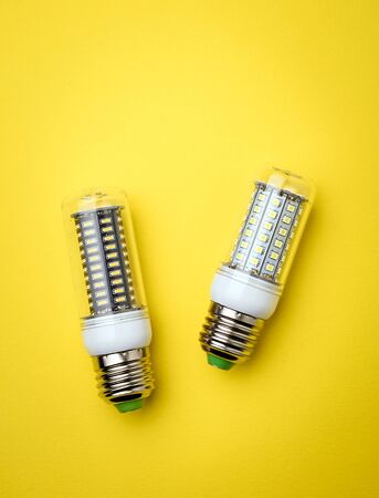 Energy saving LED light bulb on a yellow background with empty spaceの写真素材