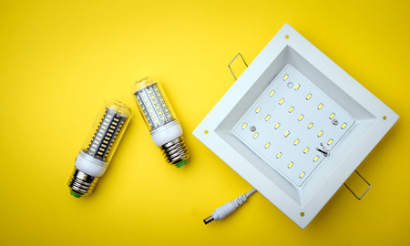 Energy saving LED light bulb on a yellow background with empty spaceの写真素材