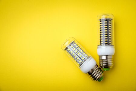 Energy saving LED light bulb on a yellow background with empty spaceの写真素材