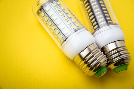 Energy saving LED light bulb on a yellow background with empty spaceの写真素材