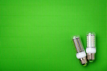 Energy saving LED light bulb on a green background with empty spaceの写真素材