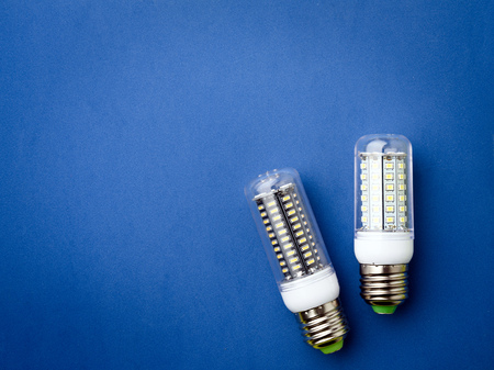 Energy saving LED light bulb on a blue background with empty spaceの写真素材