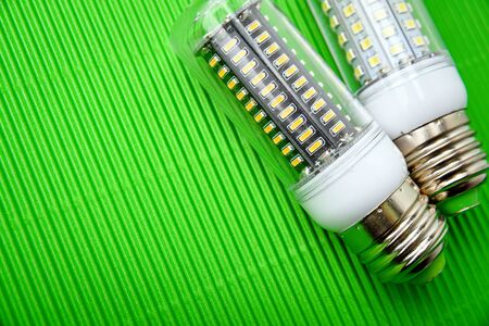 Energy saving LED light bulb on a green background with empty spaceの写真素材
