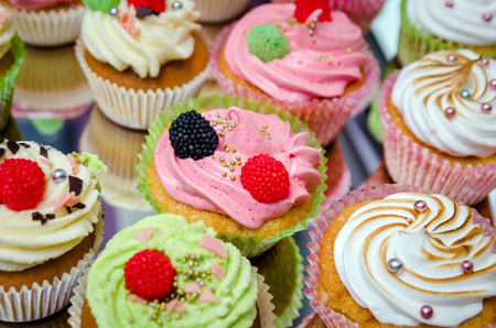 group of tasty cupcakes on a white wooden tableの写真素材