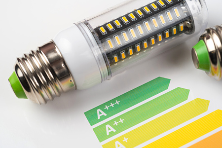 Energy efficiency concept with energy rating chart and LED lamp on white backgroundの写真素材