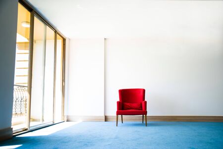 Red chair in white interiorの写真素材