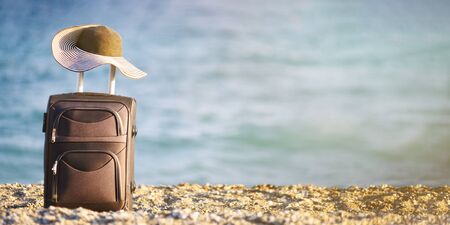 suitcase and hat on beachの写真素材