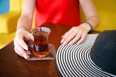 women in red dress with turkish tea on the wooden tableの写真素材